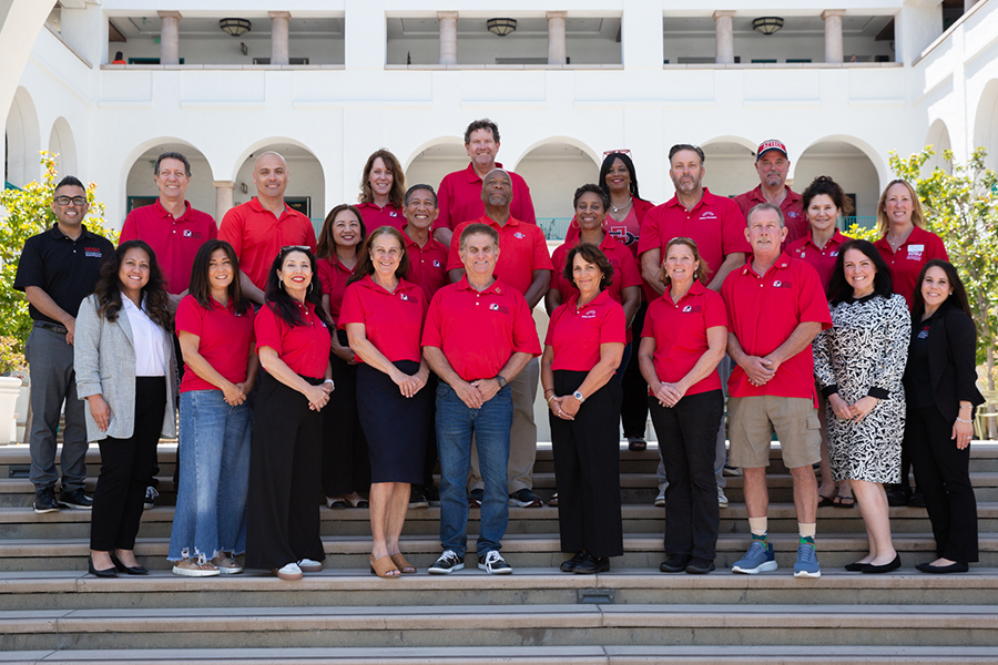 group picture of staff in red polo shirts standing in front of the union