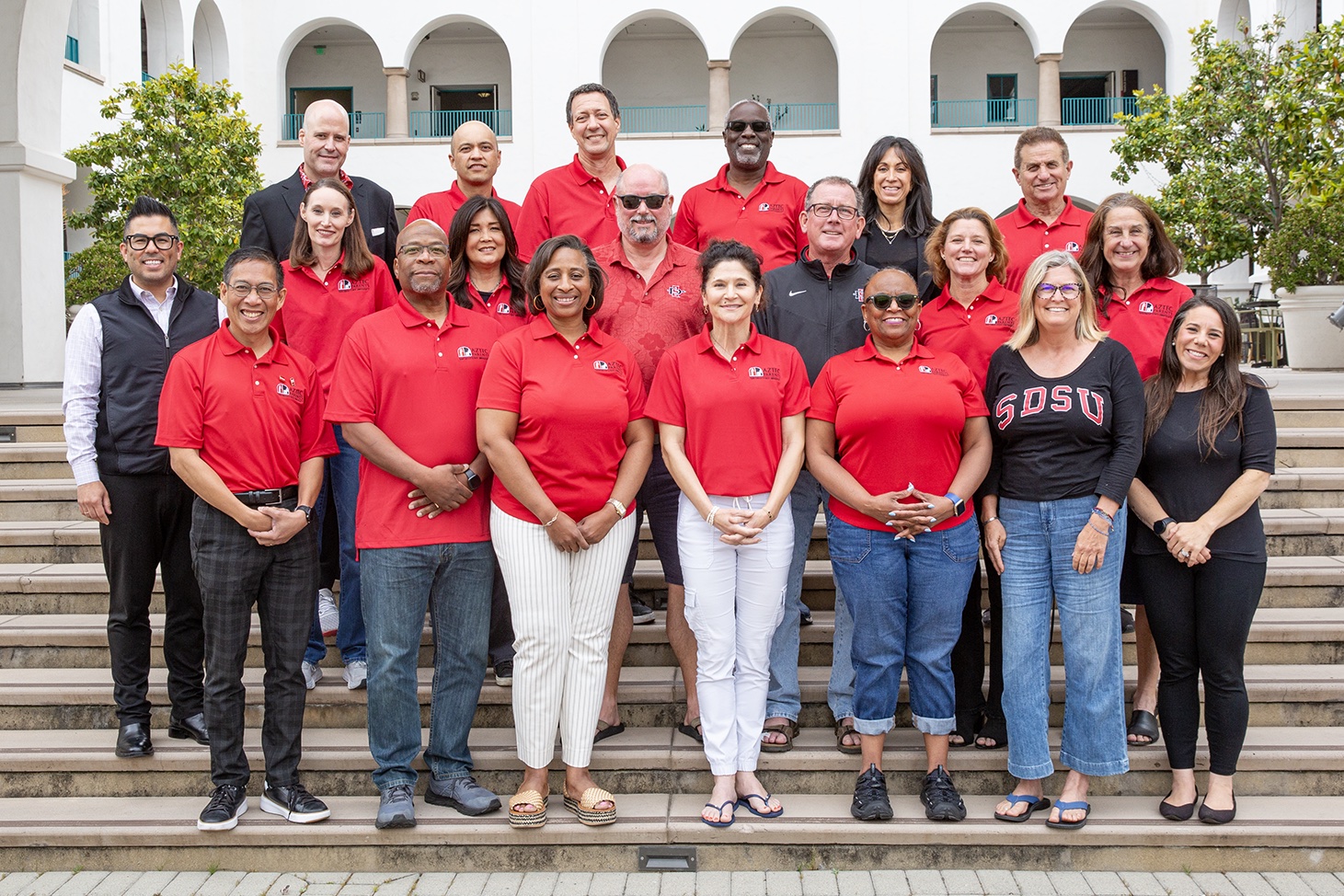 group picture of staff in red polo shirts standing in front of the union